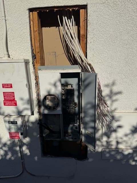 Old undersized electrical panel removed from an exterior wall during a service upgrade