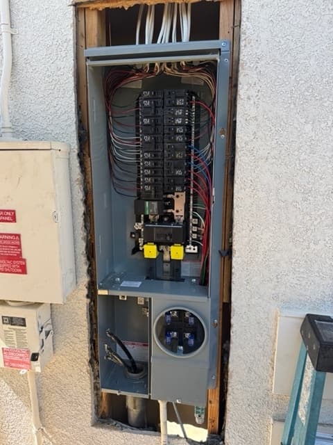 New 200-amp electrical panel set into the wall opening with circuits being landed