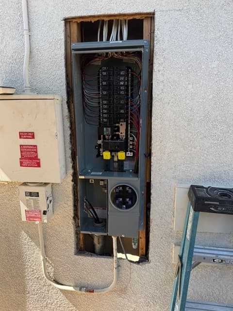 New residential electrical panel and meter main installed on an exterior stucco wall