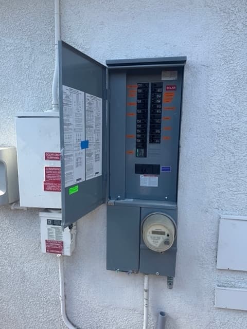 Finished electrical panel with labeled breakers including a dedicated solar circuit